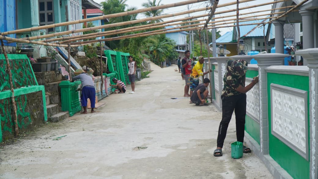 Satgas TMMD Bersama Warga Gotong Royong Cat Pagar di Desa Umbele